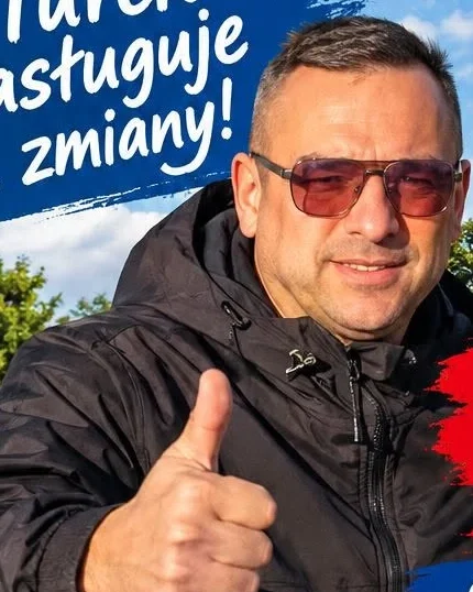 Kacper Drzewiecki w czarnej kurtce i okularach przeciwsłonecznych pokazuje kciuk w górę na tle Turku